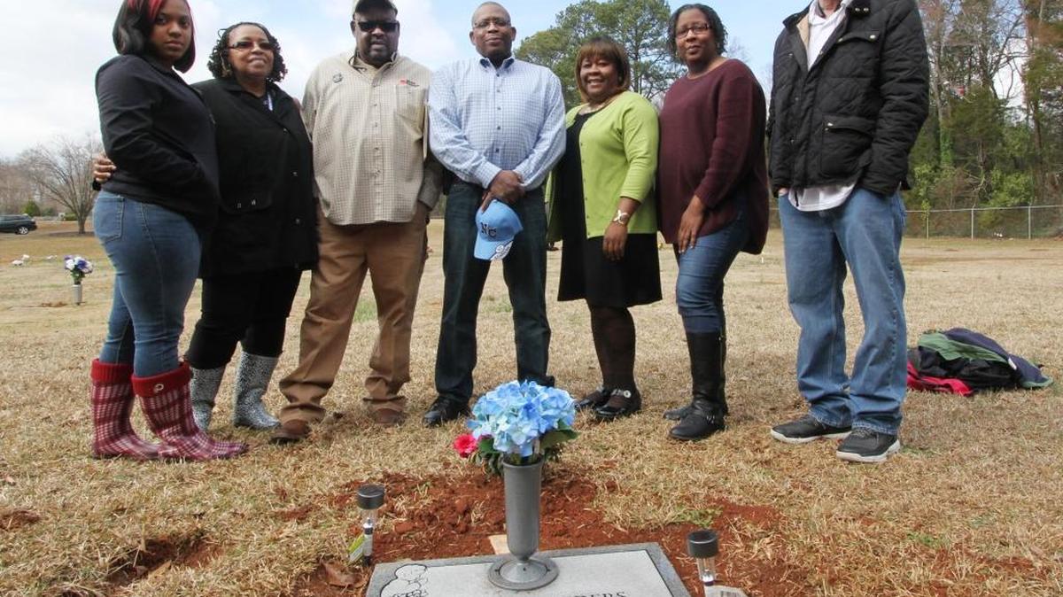 Relatives of Eugene Sanders, including six of his siblings, stand by his grave at Barber Cemetery in Rock Hill on Wednesday. Eugene died in 1957 after being hit by a car, three weeks shy of his third birthday. The siblings ordered a new headstone for their brother and installed it over the weekend.
