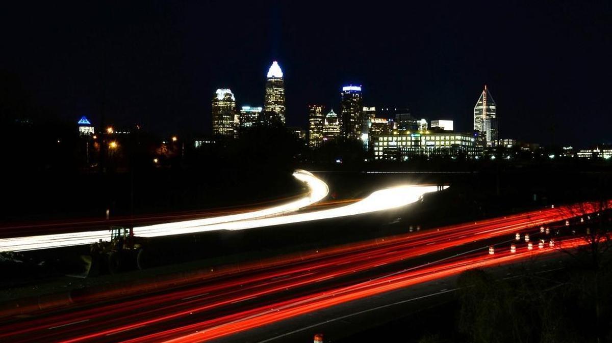 Motorists headlights and tail lights stream by on Interstate 77 near non-working lights. This view is from an overpass on Oaklawn Avenue near the I-77 S. exits for Brookshire Blvd.