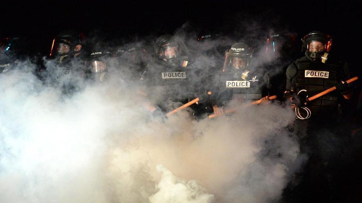 CMPD officers stand in a haze of tear gas on Old Concord Road in Charlotte on Sept. 20. A protest began after a Charlotte-Mecklenburg police officer fatally shot a man in the parking lot of The Village at College Downs apartment complex.