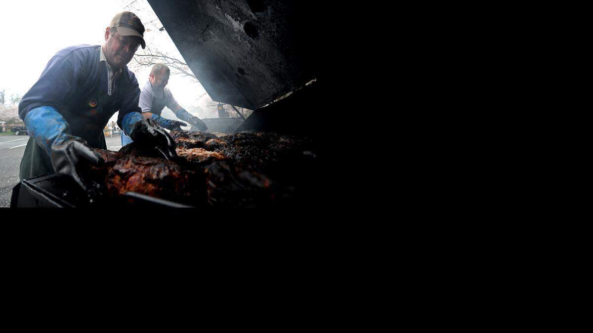 Devin Ware, left, and Ben House cook Boston butts for a Boy Scout barbecue at Providence United Methodist Church in 2015.