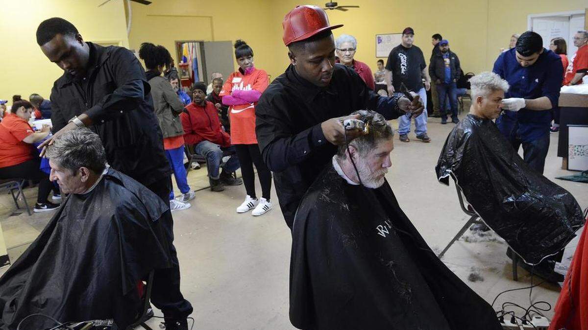 Matthew Young (center, red hat), 23, a student at Park West Barber School, gives a long-awaited haircut to Mark Cherry, 49, just a few days before Cherry turns 50. Cherry, who is homeless, says he wanted the haircut so that he could begin a job search. About 100 Charlotte area homeless people got haircuts, manicures and general health screenings at Camino Community Center, as part of the national Coca-Cola Serve Your City campaign, on Saturday, Feb. 20, 2016.