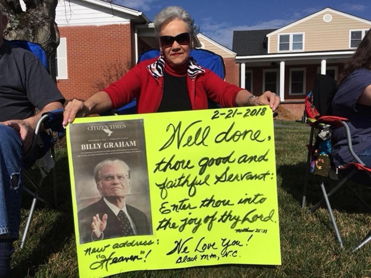 Lynda Davis of Black Mountain, who once sang at a funeral service at the Rev. Billy Graham’s home, waits for his body to pass.