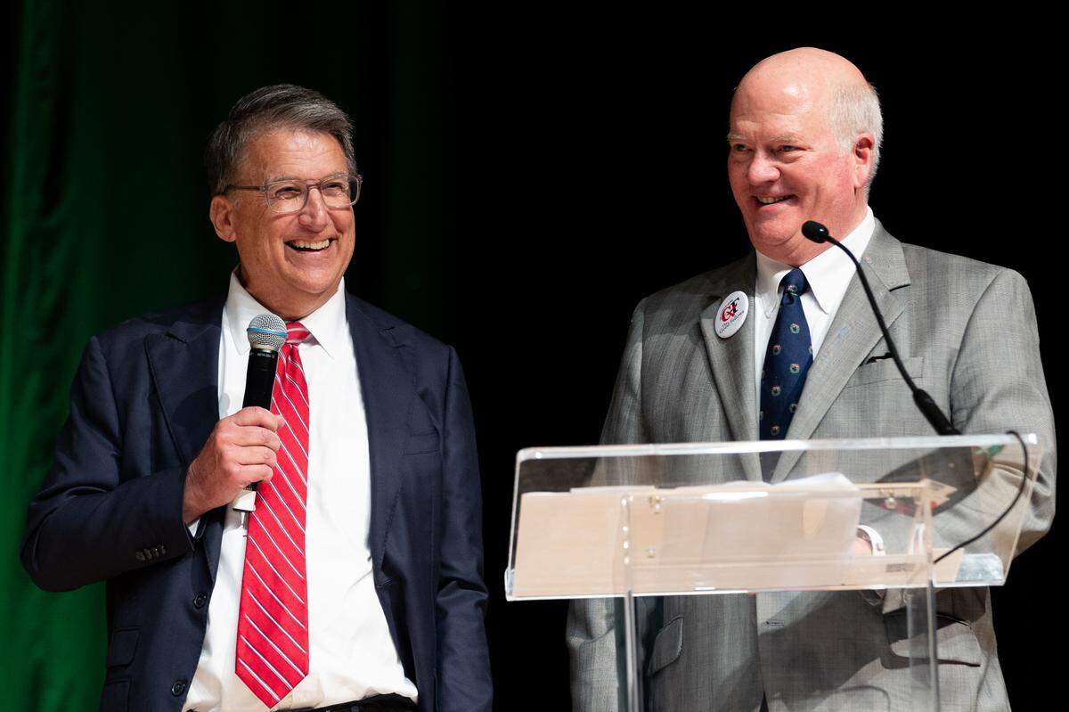 Former Governor of North Carolina Pat McCrory (left) and Vice Chair Jubal A. Early of Good Fellows joke during the Good Fellows Luncheon at the NASCAR Hall of Fame on Wednesday.