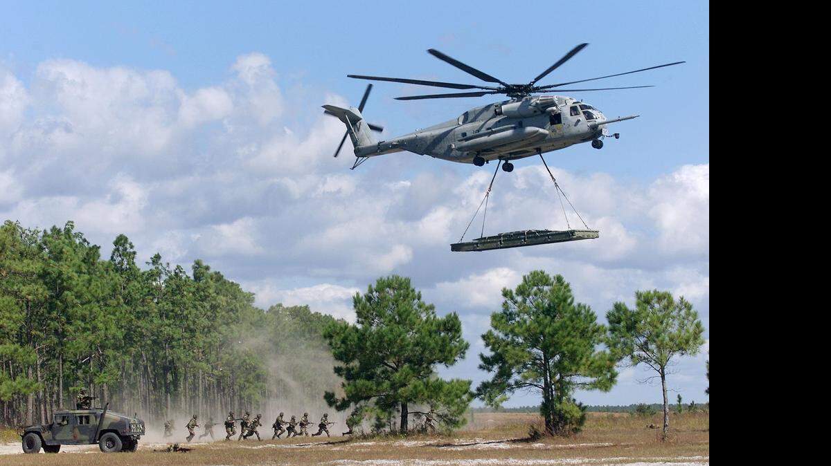 
A helicopter lowers an expandable bridge as part of a Marine Corps exercise at Camp Lejeune.
