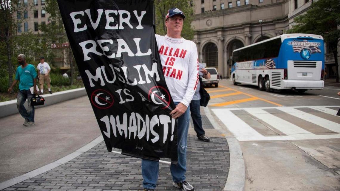 A Donald Trump supporter holds up an anti-Muslim poster as he awaits anti-Donald Trump protesters marching through the streets in Cleveland, Ohio, near the site of the Republican National Convention in July.