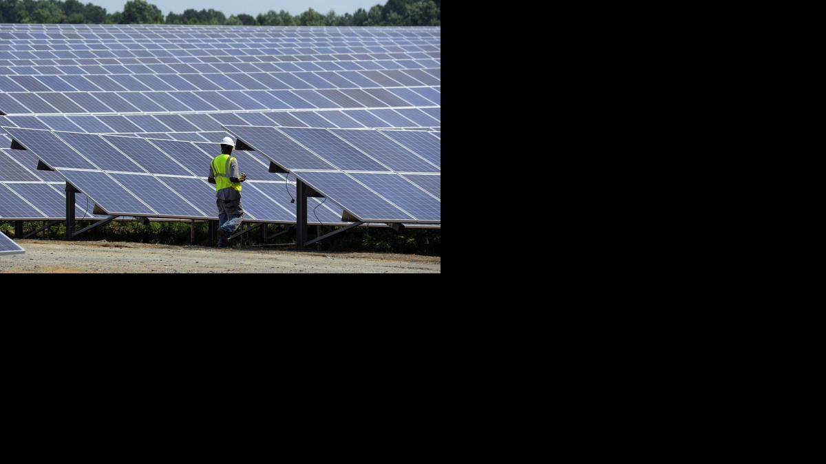 
A worker walks among a set of solar panels at an O2 Energies solar farm near Biscoe in Montgomery County last July. 
