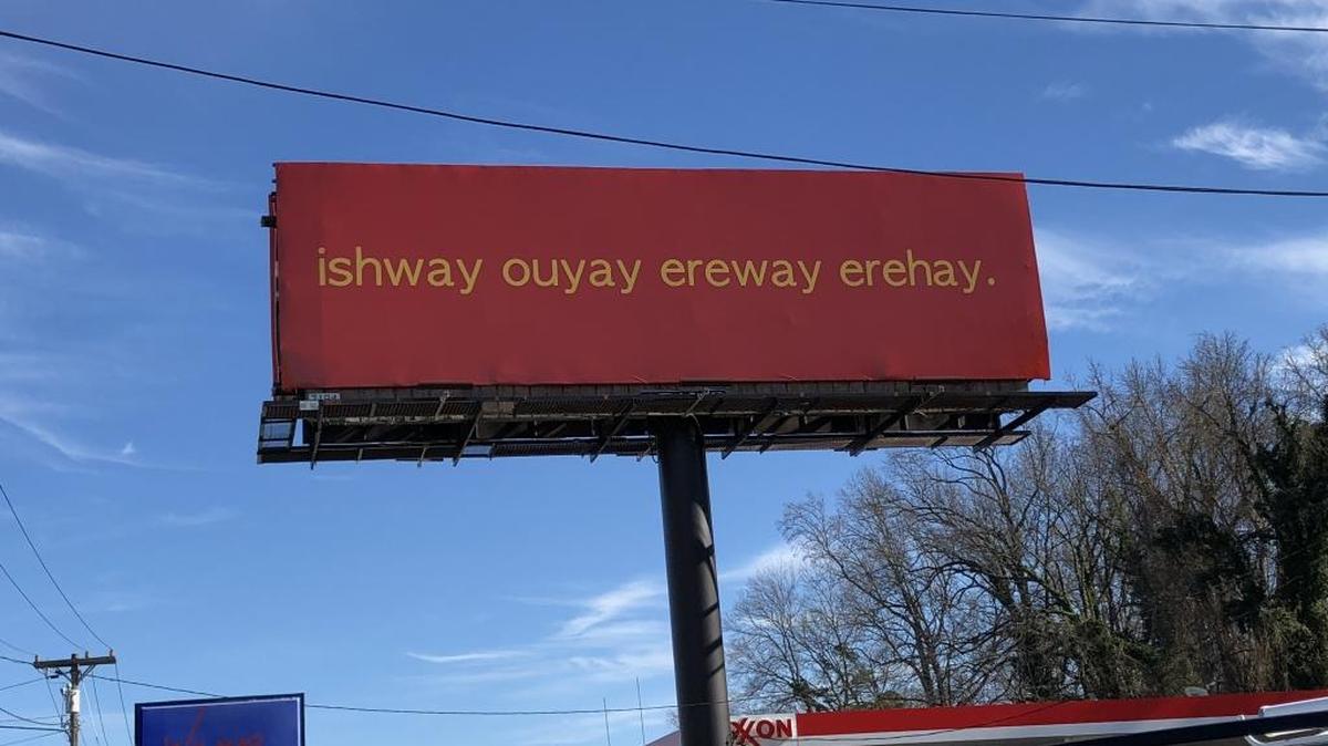 The Pig Latin billboard is just past Bojangles’ Coliseum heading away from uptown on Independence Boulevard.