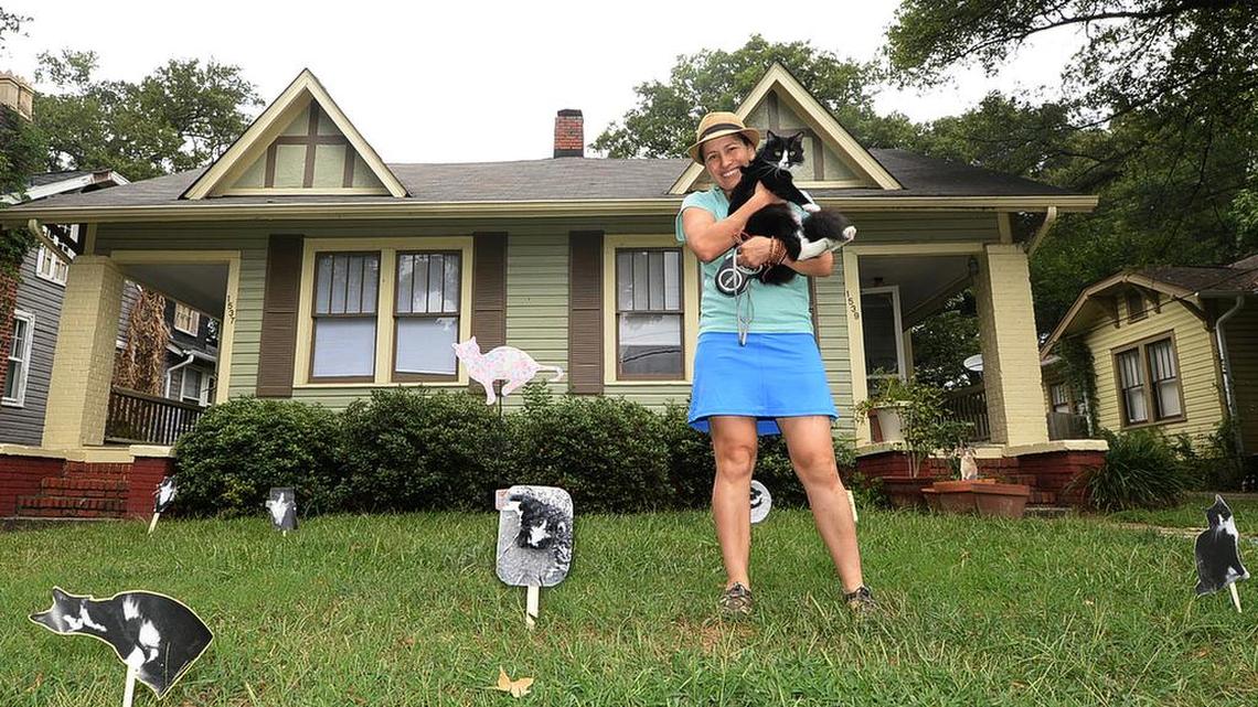 
Teresa Hernandez with her cat Miau Miau in her "Catopia" yard art display on Belvedere Ave. in Plaza-Midwood. Hernandez owns Pura Vida Worldly Art on N. Davidson St. Labor Day brings the annual Yard Art Day celebration, where people decorate their yards with unique art.
