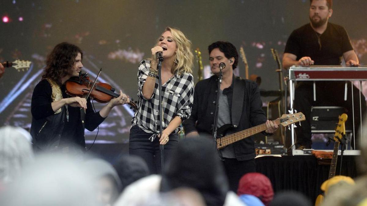 Grammy winning country music star Carrie Underwood performs for rain drenched fans during her concert at the Belk Bowl FanFest outside of Bank of America Stadium on Wednesday, December 30, 2015.