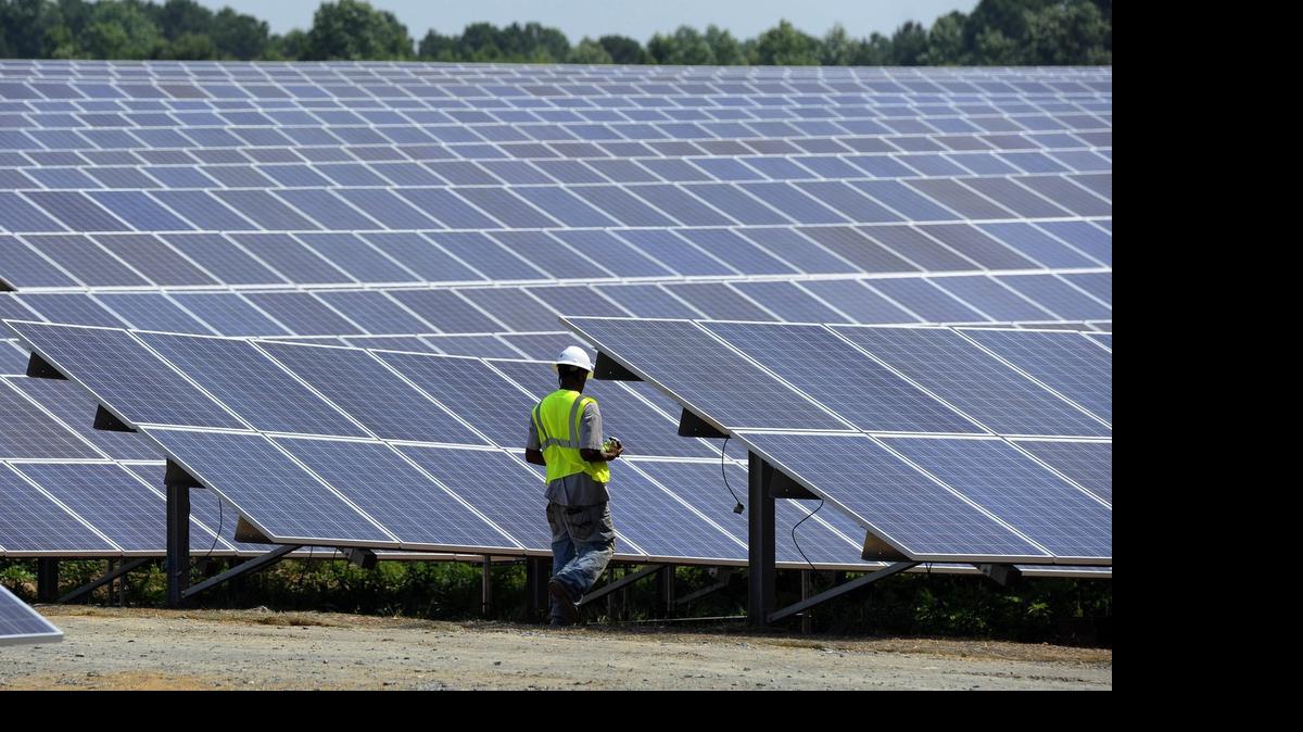 
A worker walks among an array of solar panels at an O2 Energies solar farm near Biscoe in Montgomery County.
