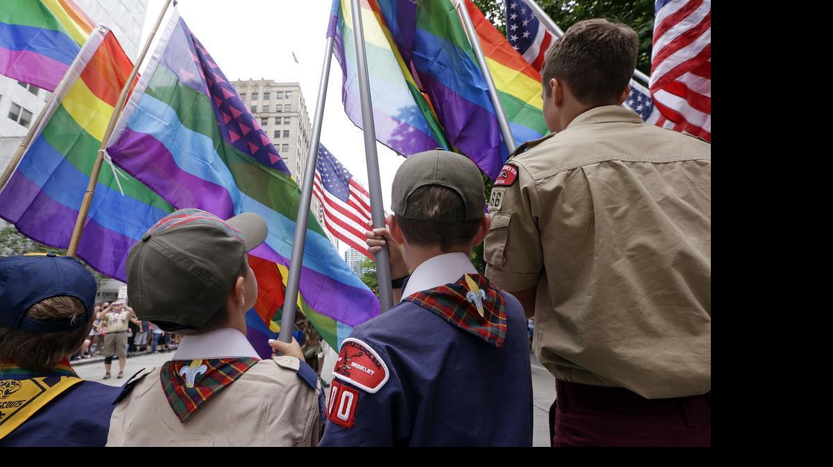 
FILE - Cub Scouts and Boy Scouts prepare to lead marchers while waving rainbow-colored flags at the 41st annual Pride Parade in Seattle. On Monday, July 27, 2015, the Texas-based Boy Scouts of America ended its blanket ban on gay adult leaders but will allow church-sponsored Scout units to maintain the exclusion for religious reasons. 

