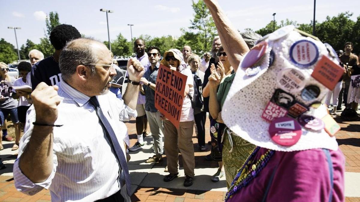 Mark Dorosin, managing attorney at the UNC Center for Civil Rights, left, chants among other protesters outside a UNC system Board of Governors committee meeting that led to an order to shut down the center’s legal work. Dorosin said on Facebook that he was fired Thursday, six weeks ahead of schedule.