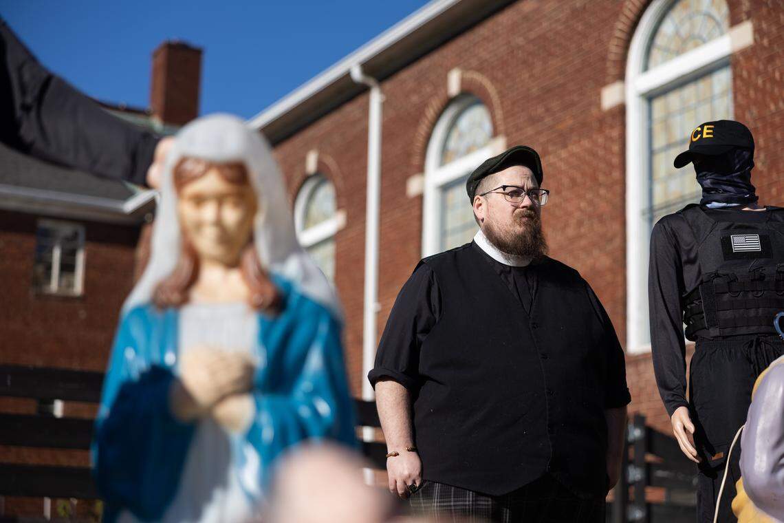 Pastor Andrew Shipley poses for a portrait among a Nativity scene that has an addition of mannequins dressed in ICE uniforms.