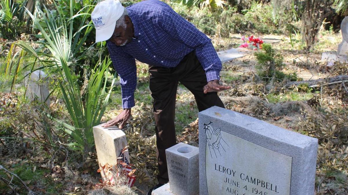 Emory Campbell surveys the tombstones of his maternal grandparents, Rosa and Perry Williams. The tombstones were spared from serious damage during the storm.