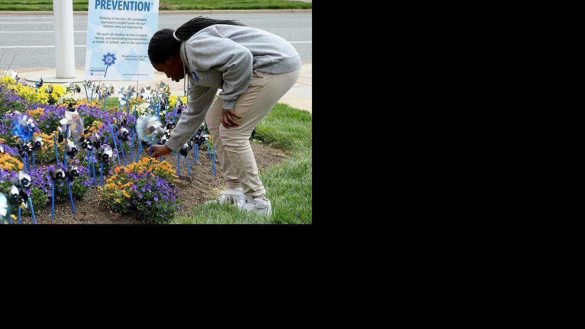 
Naryah Washington, 12, a student at James Martin Middle School, plants a pinwheel in a pinwheel garden symbolizing Child Abuse Awareness Month Thursday in front of the Charlotte-Mecklenburg Government Center. 
