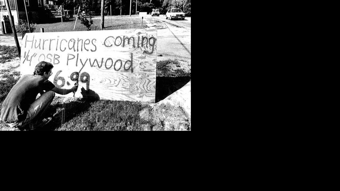 
A building supply company employee in Colington spray paints the price of plywood to protect windows in advance of Hurricane Hugo in 1989.
