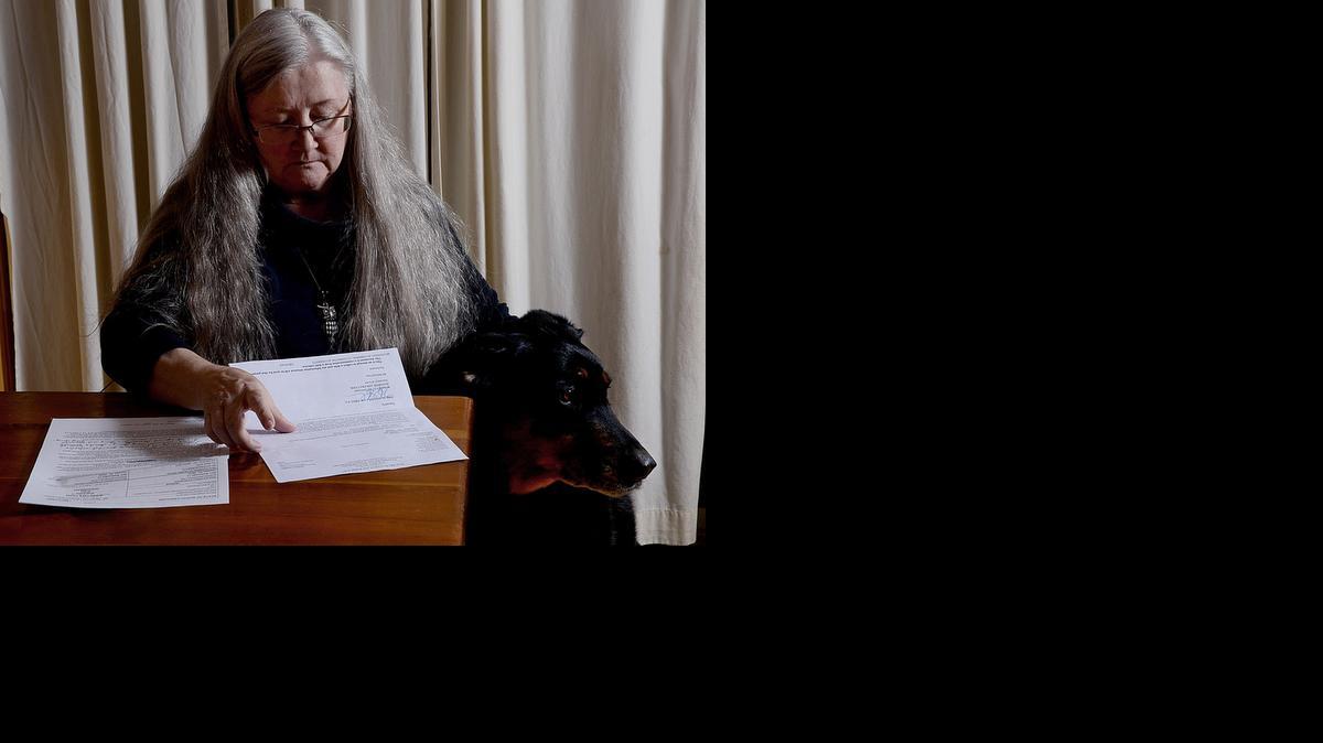 
Sharon Young looks over documents from the lawsuit that Carolinas HealthCare filed to collect on hospital bills that she says she could not afford to pay. 
