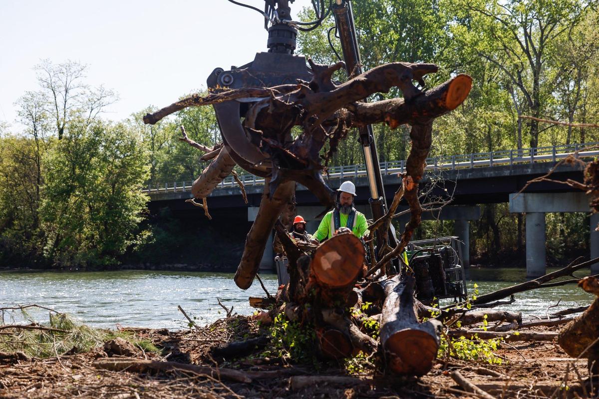 Joseph Bizzell operates the crane on a barge after collecting leftover debris from Helene in the Catawba River on Wednesday. The storm left an estimated 75,000 cubic yards of debris in the Mount Holly area of the river and Dutchman’s Creek.
