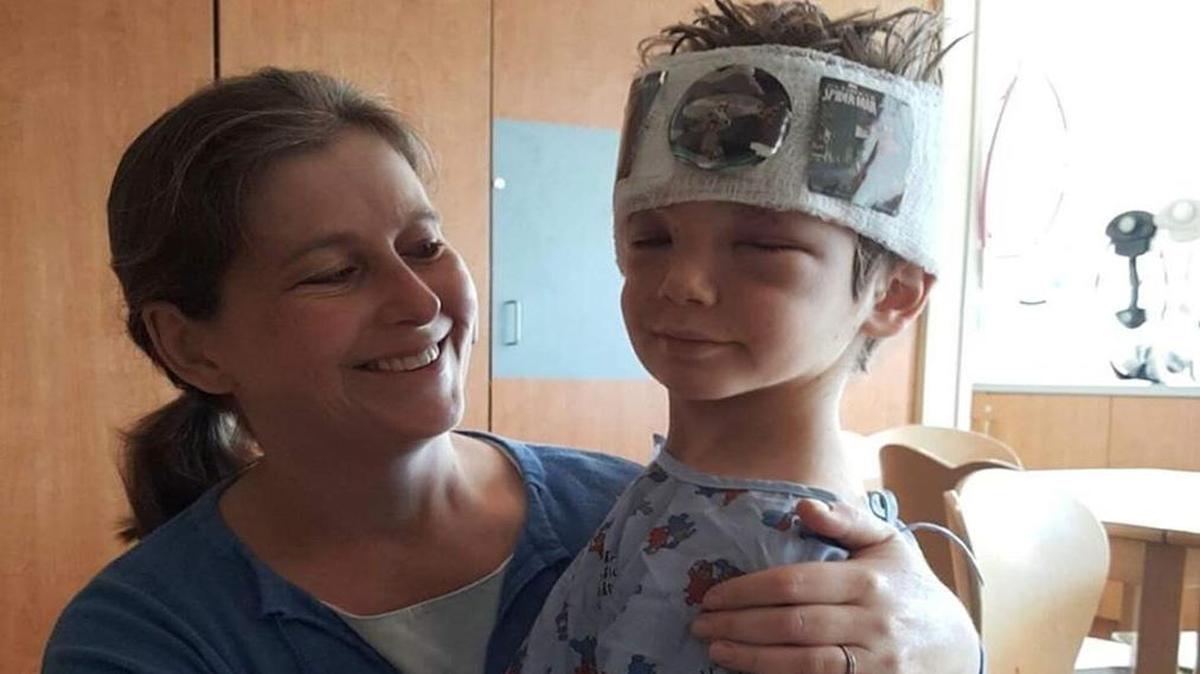 Elizabeth Bertrand and her 7-year-old son, Noah, at Levine Children’s Hospital. Noah got reconstructive surgery at the hospital after he was attacked by three bull terriers Friday.