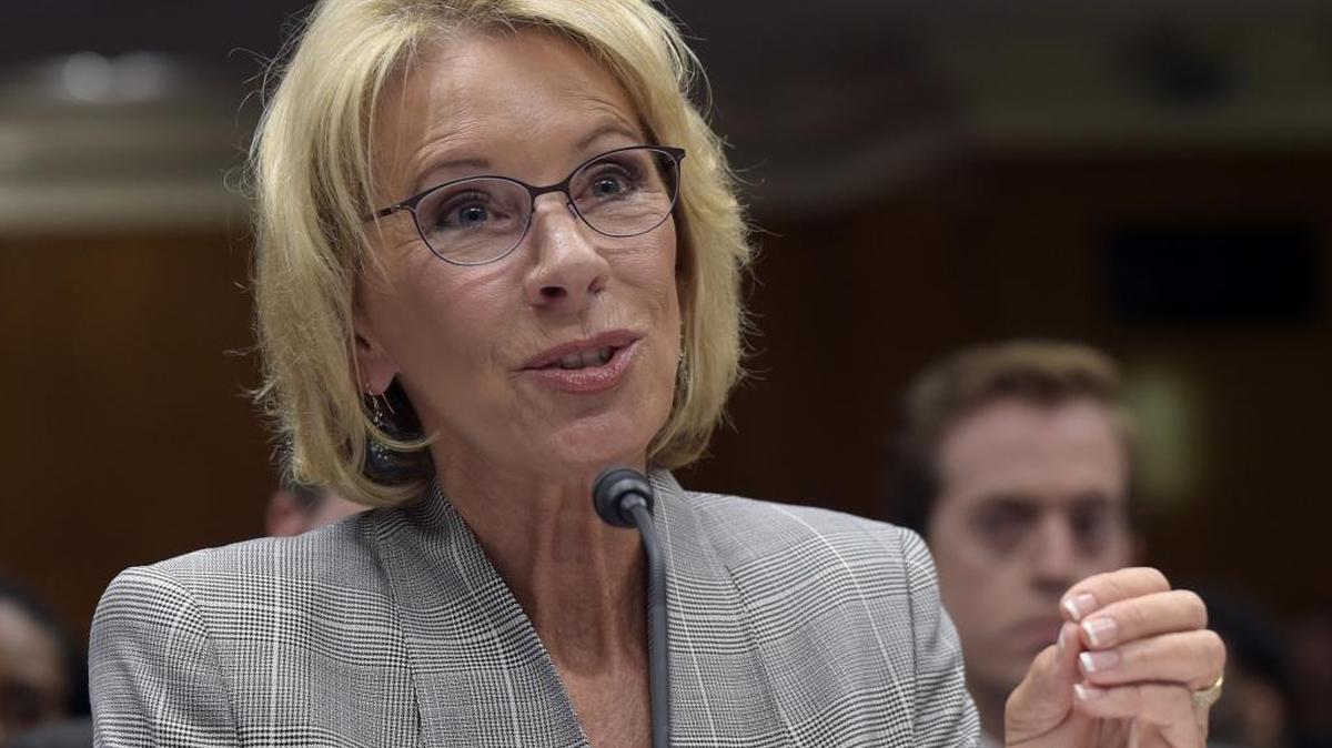 Education Secretary Betsy DeVos testifies on Capitol Hill in Washington in a hearing on the fiscal year 2018 budget. Democratic attorneys general in 18 states and the District of Columbia are suing DeVos over her decision to suspend rules meant to protect students from abuses by for-profit colleges.