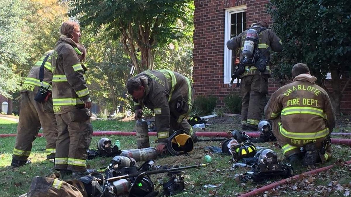 Firefighters at the scene of a house fire in south Charlotte Monday.