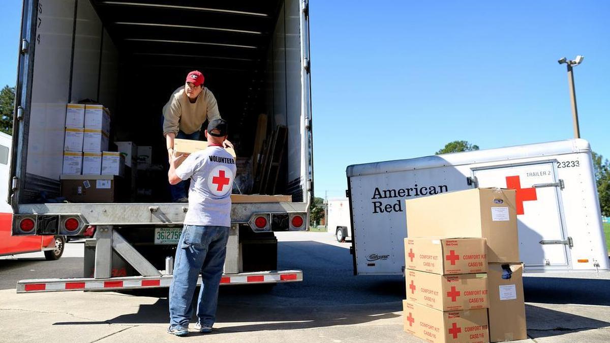 American Red Cross volunteers Stephanie Lord, top, and Chris Reynolds, unload supplies at a shelter located at Tarboro High School in Tarboro, N.C. on Monday, Oct. 10, 2016.
