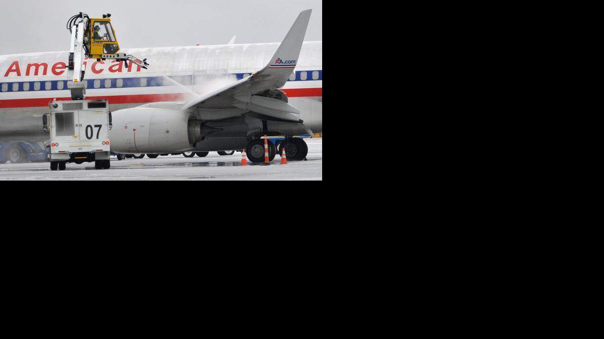 
An American Airlines jet is deiced early Tuesday morning, Feb. 17, 2015. More than 2,000 passengers spent Monday night in the terminal at Charlotte Douglas International Airport. Cots, mats, pillows and blankets were distributed. Some Airport concessionaires and checkpoints extended hours to accommodate travelers.
