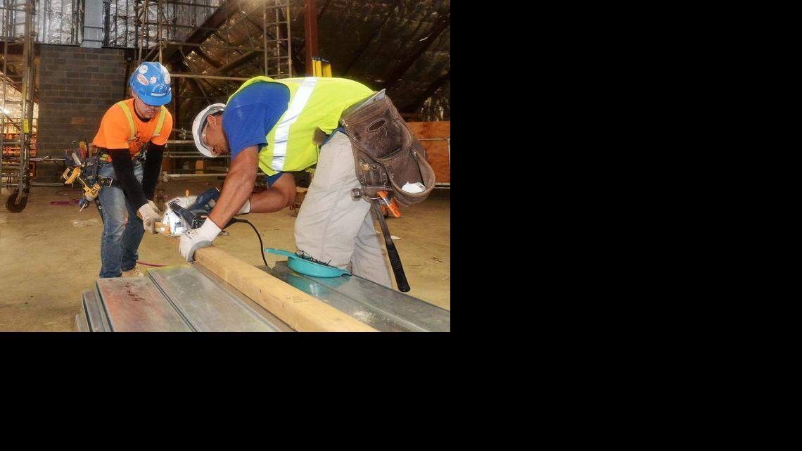 
Workers with Precision Walls of Charlotte cut lumber that will be used to protect new window openings that have been installed this month at the Salvation Army Center of Hope. 
