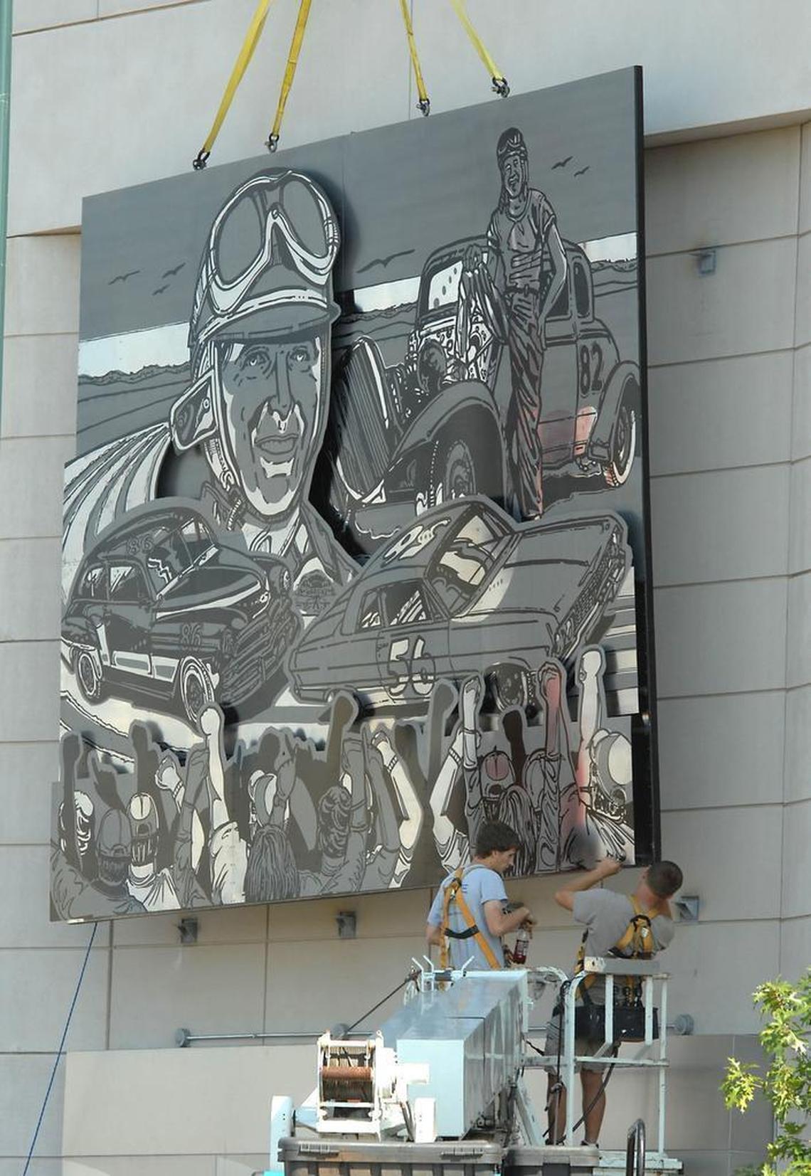 Large stainless-steel panels depicting the history of NASCAR, based on the artwork of Sam Bass, were installed in 2010 on the Stonewall Street side of the NASCAR Hall of Fame building.