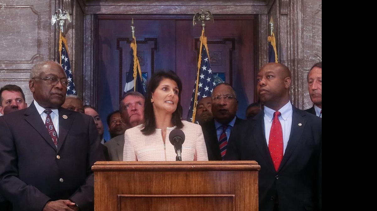
South Carolina Gov. Nikki Haley speaks during a news conference in the South Carolina State House, Monday, June 22, 2015, in Columbia, S.C. Haley said that the Confederate flag should come down from the grounds of the state capitol, reversing her position on the divisive symbol amid growing calls for it to be removed. Also pictured are U.S. Congressman James Clyburn, left, and U.S. Sen. Tim Scott, right. (Tim Dominick/The State via AP.)
