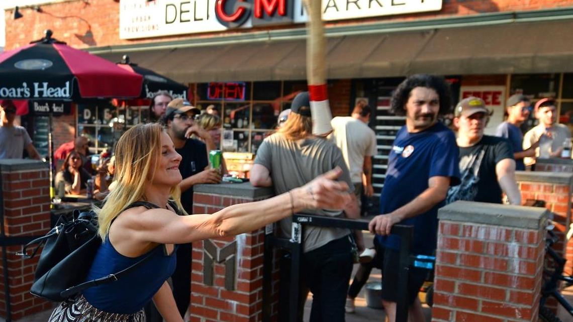 Jennifer Kilbourne of Charlotte throws an axe at Common Market in Plaza Midwood on Thursday at a mobile axe-throwing event hosted by Lumberjaxe. The business will be opening in Charlotte this fall.