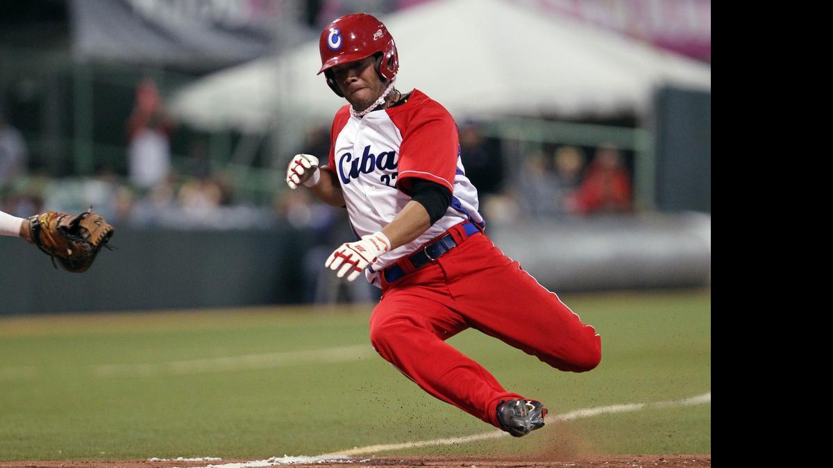 
 In this Feb. 7, 2015 file photo, Cuba’s Yadiel Hernandez slides safe  into home plate during a Caribbean Series baseball semifinal game against Venezuela in San Juan, Puerto Rico. Cuba is confirming that two baseball players, including Hernandez, have defected while in the United States for a series of friendly games against U.S. collegians. 
