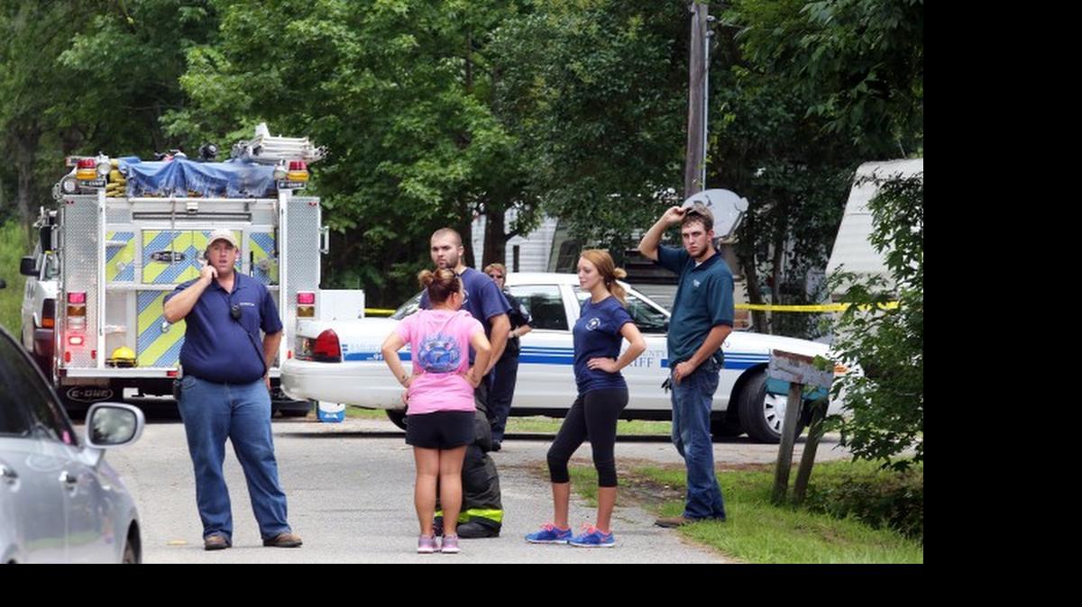 
Emergency personnel from Berkeley County stand outside a campground surrounded by police tape near Moncks Corner Tuesday, after an F-16 fighter jet smashed into a small plane over Berkeley County.
