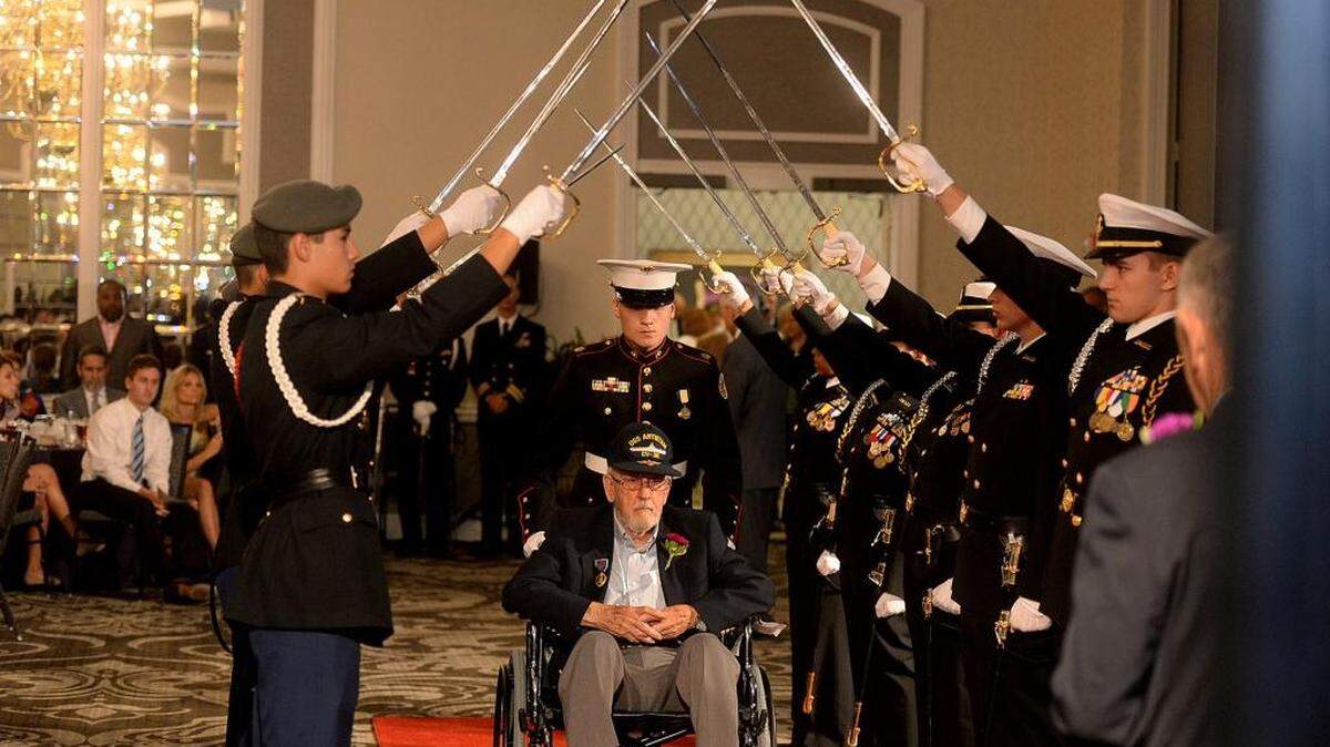 
John Higgins, who received a Purple Heart and served in the Navy during the Korean War, is escorted into Saturday's Purple Heart Dinner during the Walk of Honor. Dozens of Purple Heart recipients were honored Saturday night at the inaugural Charlotte Purple Heart Dinner at the Le Meridien Charlotte, 555 S. McDowell St. uptown. The event included a reception for Purple Heart recipients, a Walk of Honor where each Purple Heart recipient was introduced with their military branch, years of service and where and how the Purple Heart was received, an escort by Charlotte Mecklenburg Schools Junior ROTC cadets for each honoree, special recognition for those killed in action, and an elegant seated dinner. The event, hosted by the Purple Heart Foundation of North Carolina, is the first of what organizers hope will be an annual dinner for Charlotte-region recipients. 
