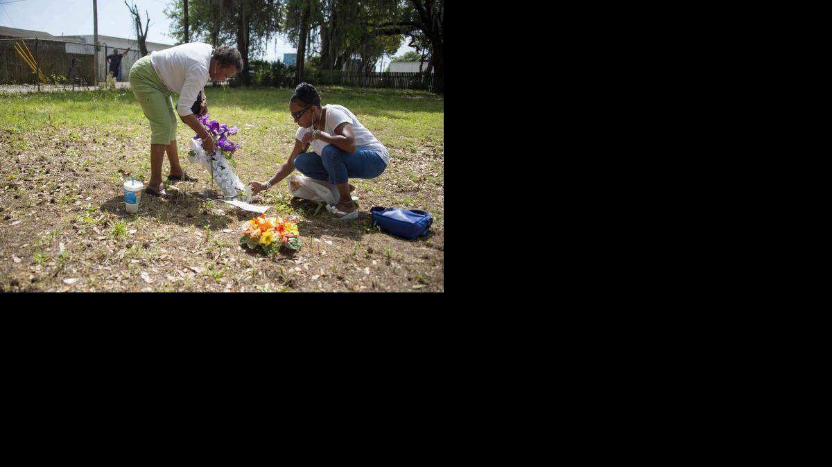 
Barbara Scott (R), cousin of Walter Scott, the 50-year-old man who was killed after being fired at eight times as he ran away from an officer after a traffic stop, lays flowers with her mother Evaliana Smalls (L) at the lot where the incident happened in North Charleston, S.C. 


