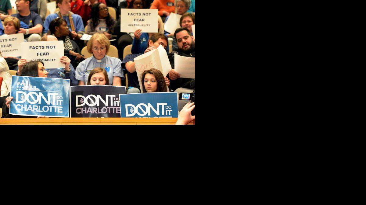 
Supporters and opponents of  the proposed nondiscrimination ordinance hold up signs inside the Charlotte-Mecklenburg Government Center prior to the start of the Charlotte City Council on Monday.
