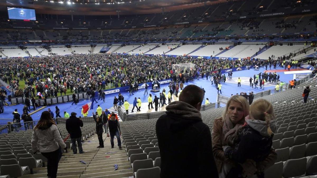 Supporters invade the pitch of the Stade de France stadium at the end of the international friendly soccer match between France and Germany in Saint Denis, outside Paris, Friday, Nov. 13, 2015. Hundreds of people spilled onto the field of the Stade de France stadium after explosions were heard nearby.
