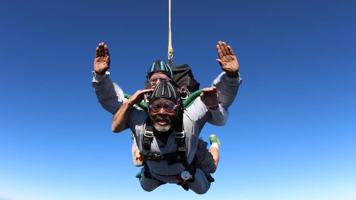 C.W. Perkins salutes while doing a tandum jump with instructor Chuck Hammond on Veterans Day Wednesday at Skydive Carolina in Chester.