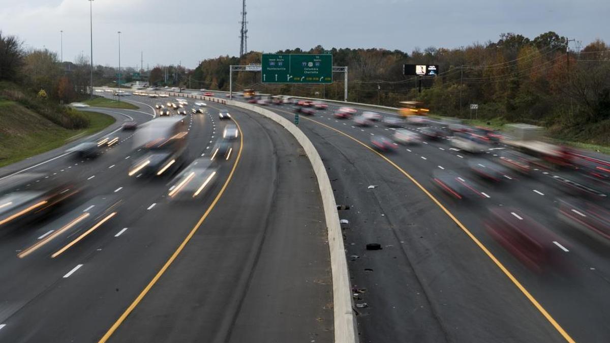 Motorists travel I-485 near I-77 north. Future toll lanes are inside the yellow lines and untraveled.