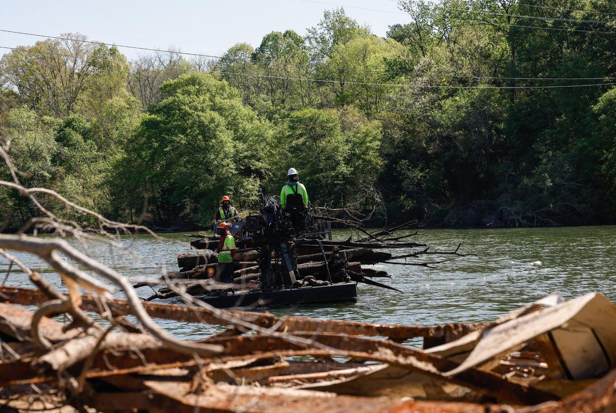 Crews with the Army Corps of Engineers and AshBritt, a natural disaster recovery company, clean leftover debris from Helene in the Catawba River near Mount Holly on Wednesday.