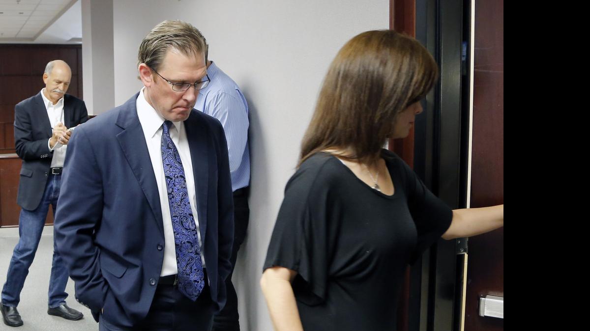 
Raleigh police Lt. Matt Kohr, left, and his wife Melanie leave the courtroom after a Wake County jury ruled Monday May 11, 2015 that Starbucks was not negligent in a case in which Kohr was severely burned when hot coffee spilled in his lap. He had sought damages of up to $750,000 from the coffee company, but the jury decided 10-2 that Starbucks owed nothing to Kohr. Both parties agreed to accept the non-unanimous verdict before they knew which direction the jury was leaning. 
