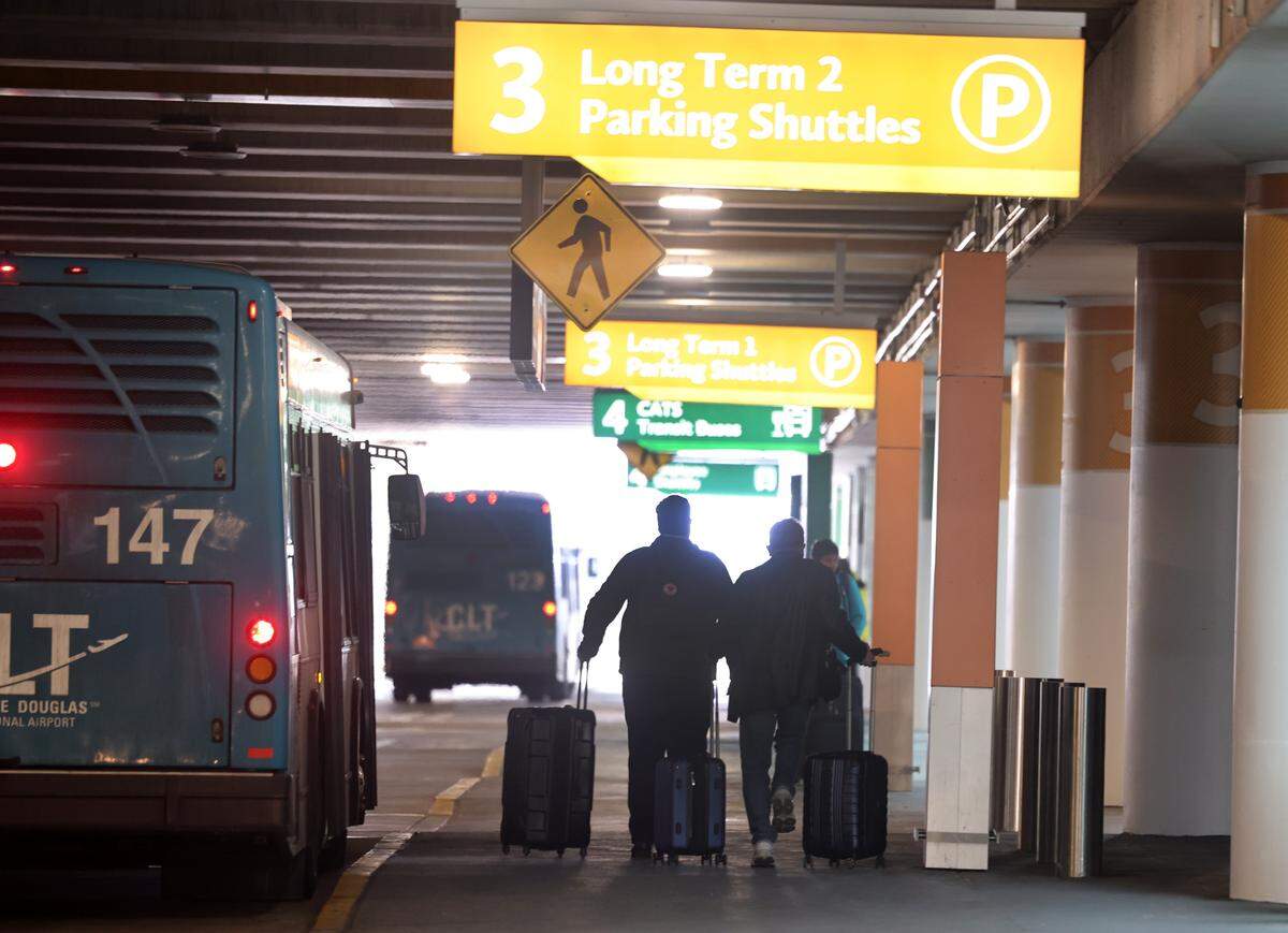 Travelers take long-term parking shuttles Wednesday, Jan. 28, 2026 at Charlotte Douglas International Airport.