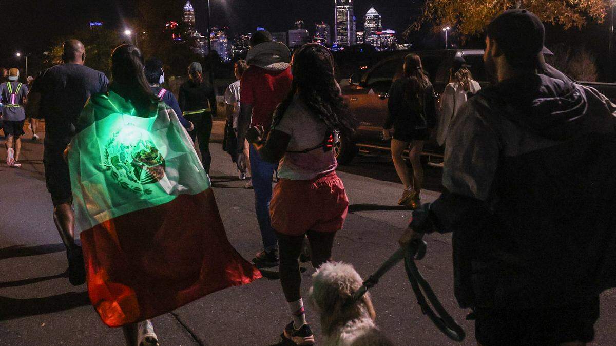 Miri Cortez dons a large Mexican flag, tied around her neck like a cape, as she joins Charlotte’s Latino run club for its weekly run on Wednesday, Nov. 19. Earlier in the week U.S. Border Patrol and Immigration and Customs Enforcement began operations in Charlotte. Despite fear in the community, the run club decided to go out and represent their culture. 