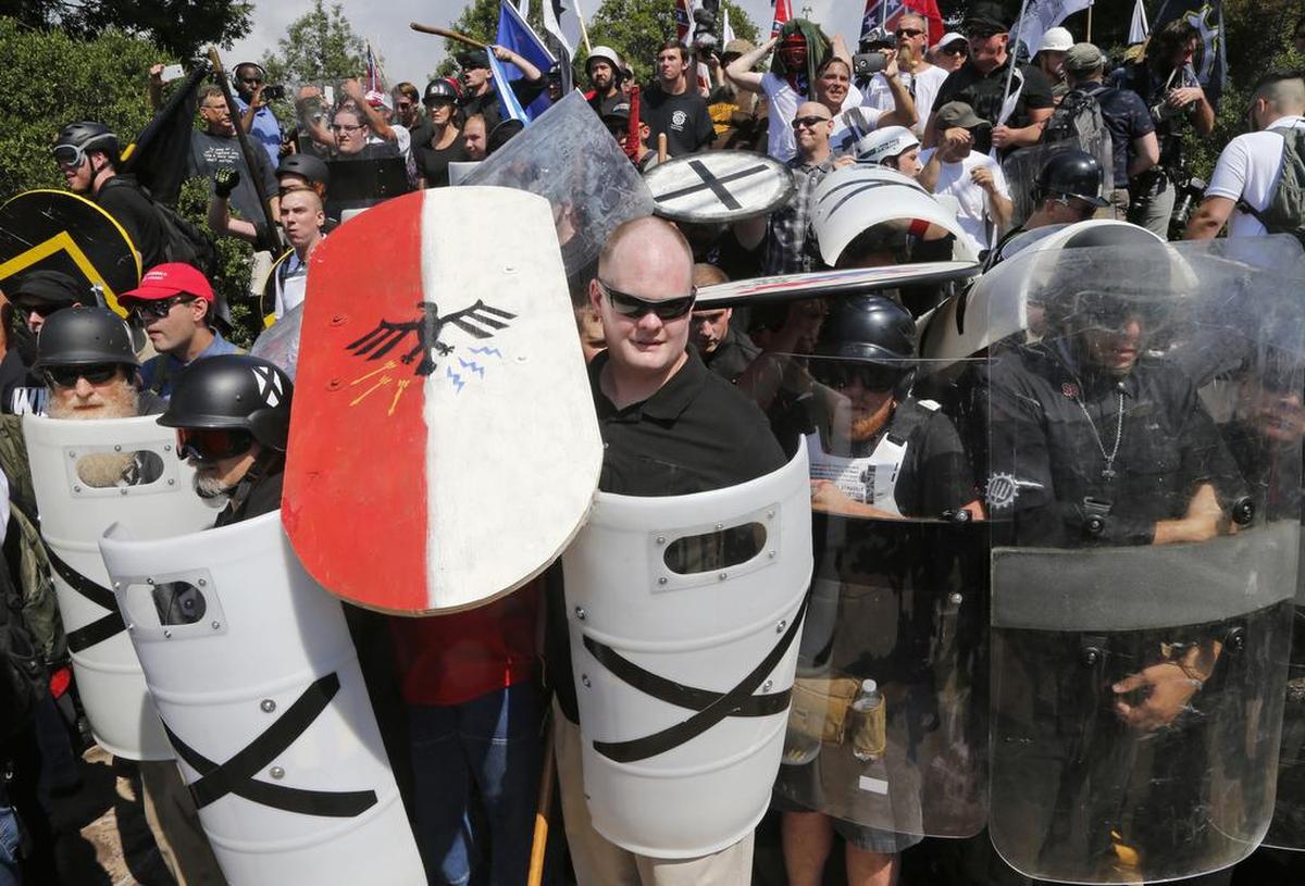 In this Aug. 12, 2017, file photo, white nationalist demonstrators use shields as they guard the entrance to Lee Park in Charlottesville, Va. The American Civil Liberties Union was reeling from criticism for its role in defending the right of white supremacists’ right to march in Charlottesvile. After that rally left a counter protester dead, some critics said the ACLU had blood on its hands.