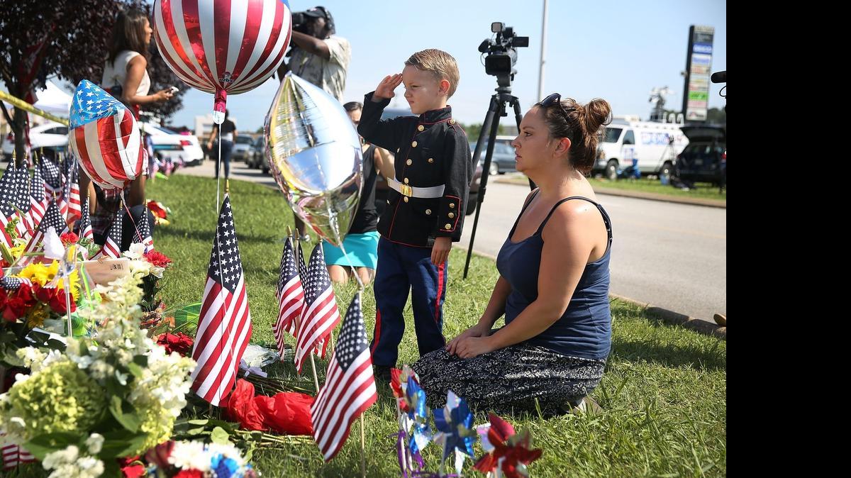 
CHATTANOOGA, TN - JULY 17: Blake Miller and his mother, Ashley Miller whose husband is a Lieutenant in the Marine Corps pay their respects to those killed while visiting a memorial placed in front of the Armed Forces Career Center/National Guard Recruitment Office which had been shot up on July 17, 2015 in Chattanooga, Tennessee. According to reports, Mohammod Youssuf Abdulazeez, 24, opened fire on the military recruiting station at the strip mall and then drove to an operational support center operated by the U.S. Navy and killed four United States Marines there, more than seven miles away.
