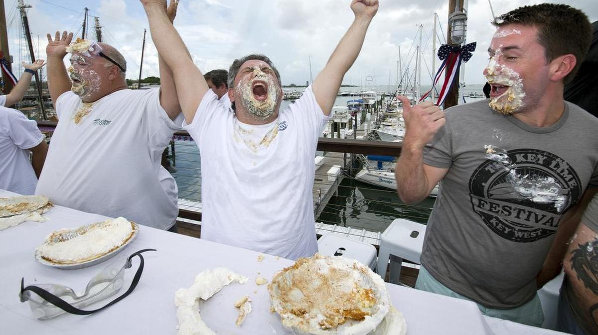 Elliot Zeller, center, raises his hands after consuming a full pie during the Mile High Key Lime Pie Eatin’ Contest on July 4, 2016, in Key West.