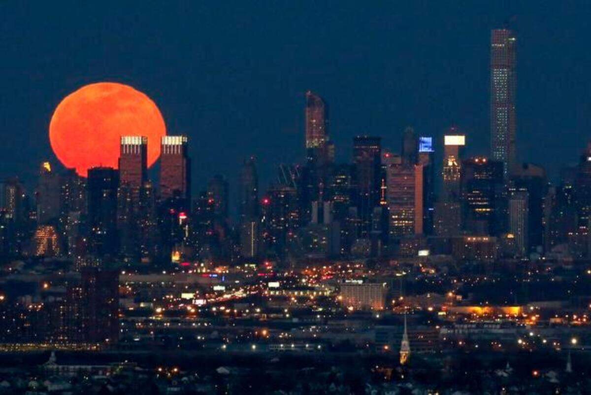 A full moon is seen as it rises over the New York City skyline seen from West Orange, N.J., Saturday, April 4, 2015. (AP Photo/Julio Cortez)