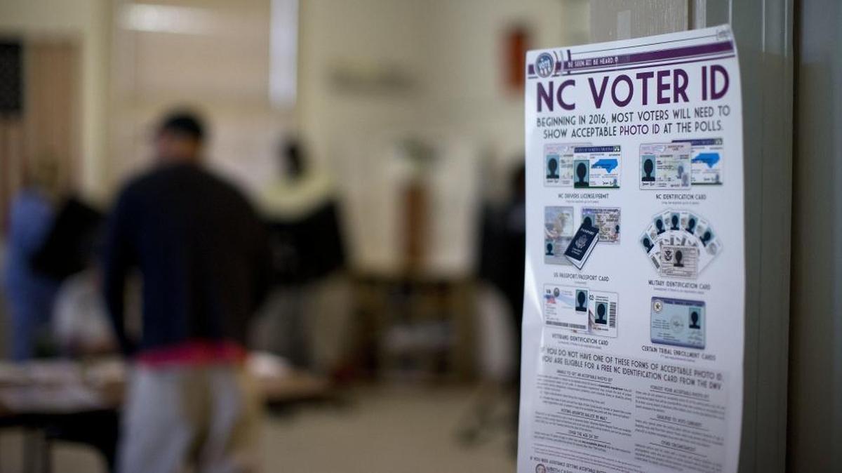 This photo taken March 15, 2016, shows North Carolina Voter ID rules posted at the door of the voting station at the Alamance Fire Station in Greensboro, N.C. A federal appeals court has since blocked a North Carolina law that required voters to produce photo identification and follow other rules disproportionately affecting minorities.