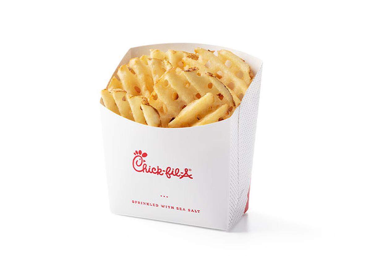 A white cardboard container filled with Chick-fil-A waffle fries is shown on a white background. The red Chick-fil-A logo and the words “SPRINKLED WITH SEA SALT” are visible on the front of the container.