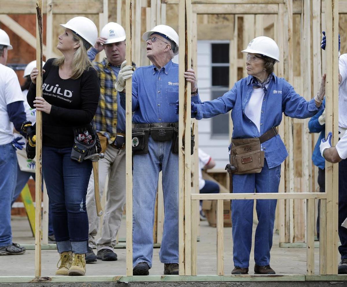 Former President Jimmy Carter works between his wife, Rosalynn Carter, right, and singer Trisha Yearwood, left, at a Habitat for Humanity building site Monday, Nov. 2, 2015, in Memphis, Tenn. Behind Yearwood is her husband, singer Garth Brooks.